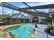A stunning covered pool area with a unique design, lush landscaping, and deck at 3805 Gaines Dr, Winter Haven, FL 33884