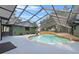 A stunning covered pool area with a unique design, lush landscaping, and deck at 3805 Gaines Dr, Winter Haven, FL 33884