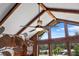 Close-up of a ceiling fan and vaulted ceiling with wooden beams complemented by a large window bringing the outside in at 3805 Gaines Dr, Winter Haven, FL 33884