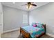 Cozy bedroom features a colorful bedspread and a ceiling fan at 3812 Cheverly E Dr, Lakeland, FL 33813