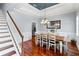 Dining room with hardwood floors, modern chandelier, and staircase access with views of kitchen at 3812 Cheverly E Dr, Lakeland, FL 33813