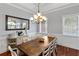Elegant dining room features a large wooden table, comfortable seating, a modern chandelier, and natural light at 3812 Cheverly E Dr, Lakeland, FL 33813
