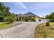 An attractive house boasts a long driveway, well-manicured lawn, mature landscaping, and a 2-car garage at 3812 Cheverly E Dr, Lakeland, FL 33813