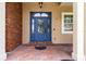 Elegant blue front door with decorative glass and brick accents enhances curb appeal at 3812 Cheverly E Dr, Lakeland, FL 33813