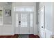 Bright entryway featuring a decorative glass front door, wainscoting, hardwood floors, and transom window at 3812 Cheverly E Dr, Lakeland, FL 33813
