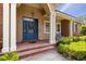 Attractive front entrance with a blue door, brick accents, and manicured landscaping creates a welcoming entryway at 3812 Cheverly E Dr, Lakeland, FL 33813