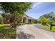 Charming single-story home featuring a long driveway and beautifully landscaped front yard with mature trees and manicured shrubs at 3812 Cheverly E Dr, Lakeland, FL 33813