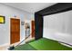 Home golf simulator with golf training equipment and access to a bathroom at 3812 Cheverly E Dr, Lakeland, FL 33813