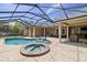 Paver pool deck with a spa and chairs inside a screened enclosure at 3812 Cheverly E Dr, Lakeland, FL 33813