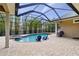 Screened-in pool area featuring a pool, spa, tiled flooring, and backyard landscaping at 3812 Cheverly E Dr, Lakeland, FL 33813
