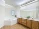 Bright bathroom with double vanity, soaking tub, and wood-look flooring at 3852 Serenade Ln, Lakeland, FL 33811