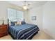 Cozy bedroom with striped bedding, ceiling fan, and a window with blinds at 3852 Serenade Ln, Lakeland, FL 33811
