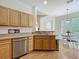 Functional kitchen featuring wood cabinets, stainless steel dishwasher, and a view of the dining area at 3852 Serenade Ln, Lakeland, FL 33811