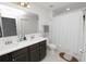 Bathroom with a double sink vanity, white tiled floors, and a walk-in shower at 3857 Hampstead Ln, Lakeland, FL 33810