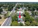 Aerial view of the home and surrounding neighborhood, showcasing the green roof, lush trees, and nearby road at 3880 Cleveland Heights Blvd, Lakeland, FL 33813
