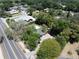 Aerial view showcasing the green roof of this home, mature trees, the driveway and the neighborhood streets at 3880 Cleveland Heights Blvd, Lakeland, FL 33813