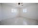 Bright bedroom with white walls, speckled flooring, ceiling fan and two windows with white shutters at 3880 Cleveland Heights Blvd, Lakeland, FL 33813