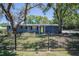 Charming single-story home features a well-manicured lawn, decorative fence, and a bright yellow front door at 3880 Cleveland Heights Blvd, Lakeland, FL 33813