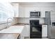 Well-lit kitchen with stainless appliances, white cabinetry, and decorative backsplash at 3880 Cleveland Heights Blvd, Lakeland, FL 33813