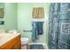 Cozy bathroom featuring a vanity with light countertops, toilet, decorative shower curtain with a seashells and sea stars at 3942 Warbler Dr, Winter Haven, FL 33880