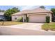 Traditional home featuring a two-car garage, concrete driveway, and manicured landscaping at 3942 Warbler Dr, Winter Haven, FL 33880