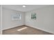 Well-lit bedroom featuring luxury vinyl flooring, two windows, and neutral paint at 4028 S Wellington Dr, Lakeland, FL 33813