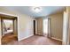 Bedroom featuring carpeted floors, tan walls, single window with blinds, closet, and two doorways at 410 Orange St, Bradley, FL 33835