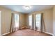 Bedroom featuring carpeted floors, tan walls, multiple windows with blinds, and neutral-colored curtains at 410 Orange St, Bradley, FL 33835