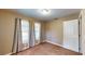 Bedroom featuring carpeted floors, tan walls, two windows with blinds, and neutral-colored curtains at 410 Orange St, Bradley, FL 33835