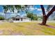 Spacious front yard with mature trees and a quaint home featuring a screened porch at 410 Orange St, Bradley, FL 33835