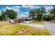 Exterior view of home showcasing a carport, screened porch, gravel driveway, and spacious front yard at 410 Orange St, Bradley, FL 33835