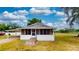 Charming single-story home with a screened-in porch and a bright white exterior under a blue sky at 410 Orange St, Bradley, FL 33835