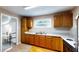 Well-lit kitchen featuring wooden cabinets, countertops, a double sink, and laminate flooring at 410 Orange St, Bradley, FL 33835