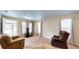 Bright living room with carpet flooring, three large windows, and cozy seating at 410 Orange St, Bradley, FL 33835