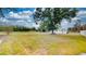 Large, open front yard featuring mature trees and a cozy home in a peaceful setting at 410 Orange St, Bradley, FL 33835