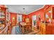 Classic dining room with red walls, hardwood floors, chandelier and a rustic wood table at 410 S Broadway Ave, Bartow, FL 33830