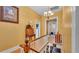 Hallway featuring hardwood floors, yellow walls, and a charming antique desk at 410 S Broadway Ave, Bartow, FL 33830