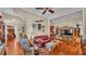 Cozy living room with hardwood floors, leather couch, curated decor, and a ceiling fan at 410 S Broadway Ave, Bartow, FL 33830