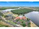 Stunning aerial view of a community clubhouse with pool, tennis courts, and lush landscaping by the water at 4219 Windchime Ln, Lakeland, FL 33811