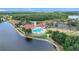 An aerial view of a clubhouse, pool, and parking area beside a scenic lake at 4219 Windchime Ln, Lakeland, FL 33811