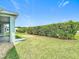 Spacious backyard featuring lush green grass and mature hedges, offering privacy and a serene outdoor space at 4219 Windchime Ln, Lakeland, FL 33811