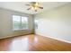 An empty bedroom features a ceiling fan, wood-look flooring, and windows at 4219 Windchime Ln, Lakeland, FL 33811