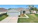 Charming single-story home featuring a well-maintained lawn, two-car garage, and inviting front entryway at 4219 Windchime Ln, Lakeland, FL 33811
