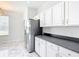 Bright kitchen features white cabinets, dark countertops, stainless fridge, and tiled flooring at 4219 Windchime Ln, Lakeland, FL 33811