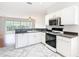 Well-equipped kitchen featuring white cabinetry, dark countertops, and stainless appliances in open layout at 4219 Windchime Ln, Lakeland, FL 33811
