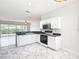 Stylish kitchen featuring white cabinets, black appliances, and easy access to the living room at 4219 Windchime Ln, Lakeland, FL 33811