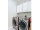 A laundry room features a washer and dryer with white storage cabinets at 4219 Windchime Ln, Lakeland, FL 33811