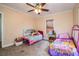 Comfortable bedroom with two beds, a ceiling fan, and neutral tones at 422 E Belmar St, Lakeland, FL 33803