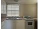 A kitchen with a sink, white cabinets, and a stove, showcasing a functional space at 422 E Belmar St, Lakeland, FL 33803