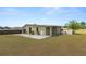 A detached garage and backyard with a concrete patio and green grass at 5201 Dorman Rd, Lakeland, FL 33813